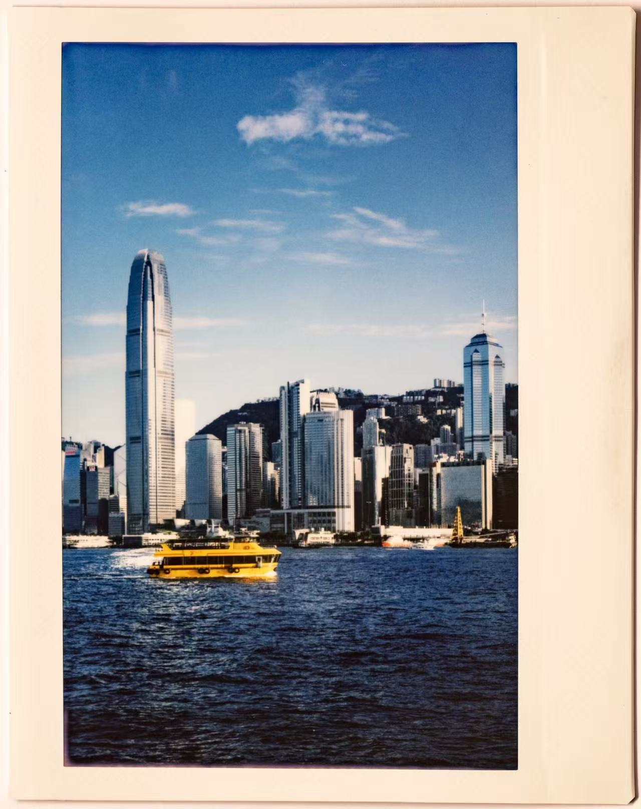 A film photograph of Hong Kong harbour with a yellow ferry